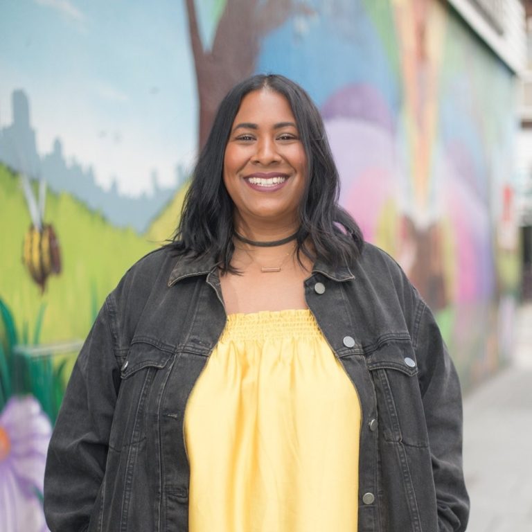 Selina Ocean stood smiling in front of a mural